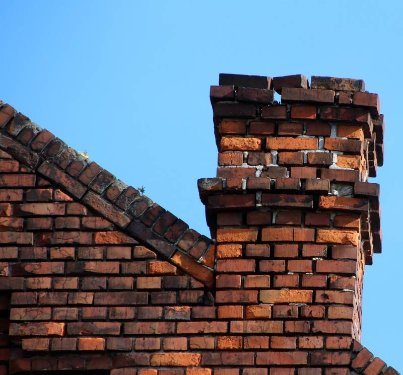 Damaged chimney on an Oakbrook home showing cracks and missing mortar
